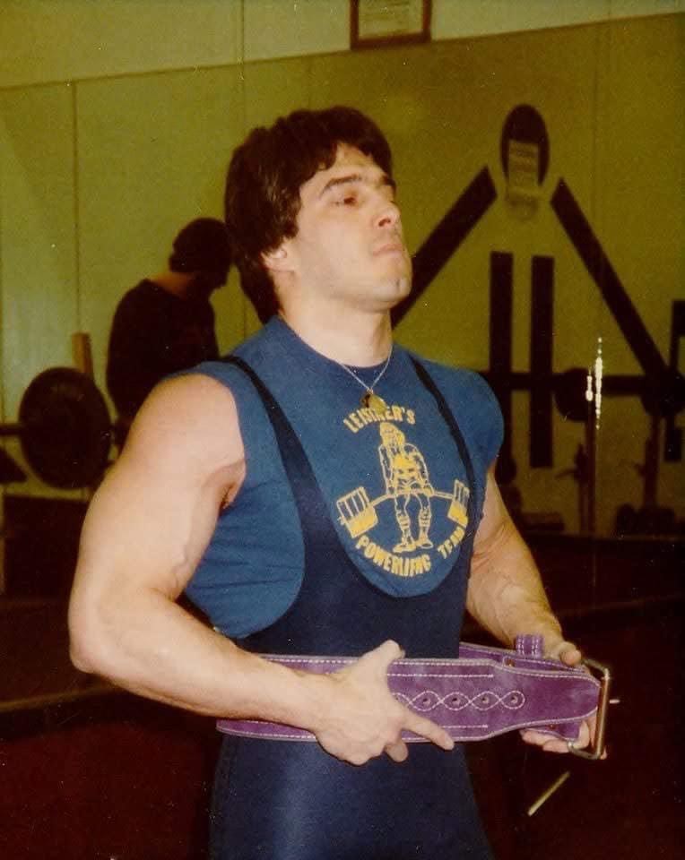 Dr. Ken Leistner wearing a powerlifting belt in the gym